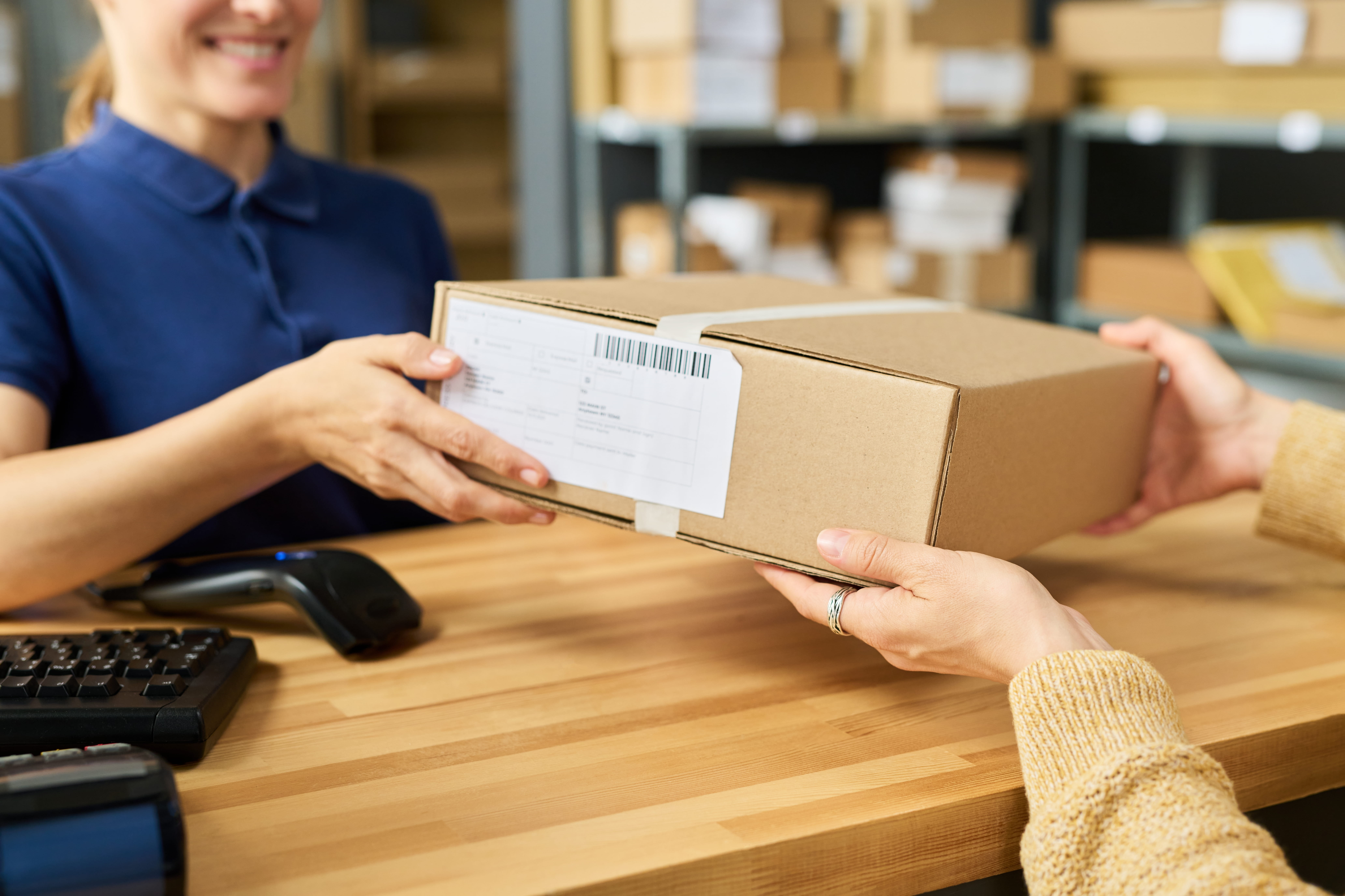 delivery person handing a package to a receptionist